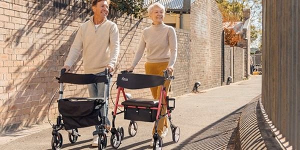 Two seniors walking on the street with Altus walkers.