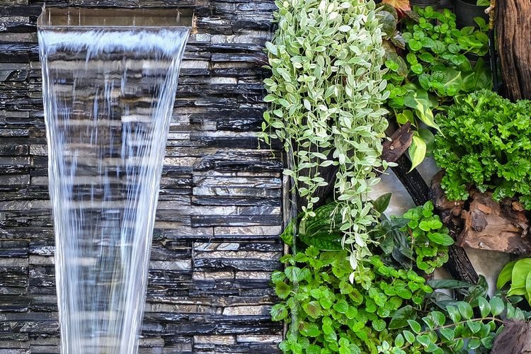 Water fountain pouring from feature wall