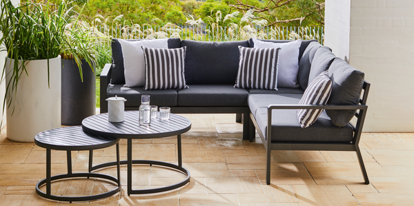 Couch, plants and a coffee table in an outdoor area