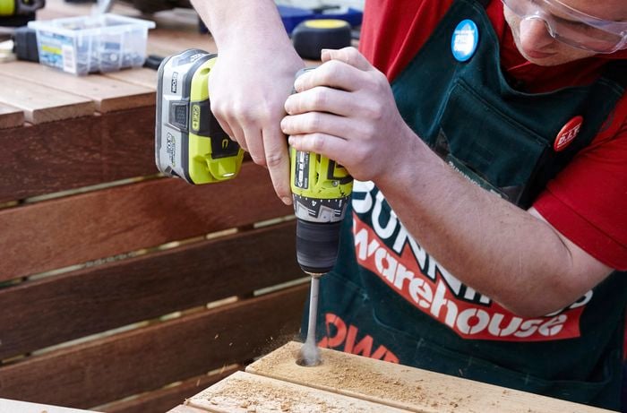 Person drilling a hole in timber.
