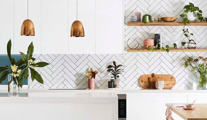 Kitchen with white benches and white tiles.