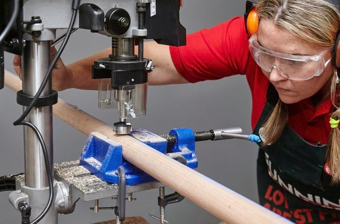 Person about to drill holes in timber using wide drill bit.
