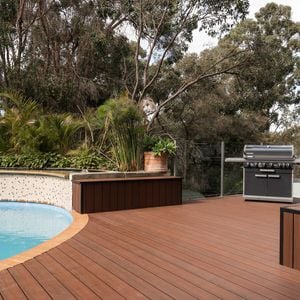 Outdoor area with decking, a pool and a barbecue.