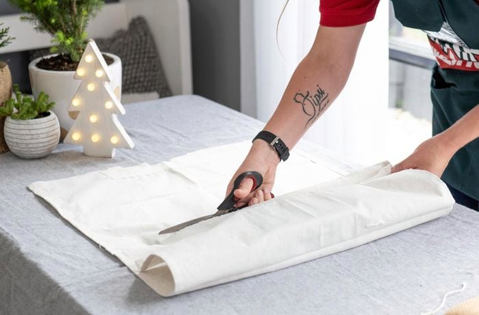 Person cutting fabric with scissors.
