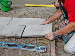 Person laying pavers.