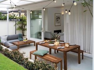 Outdoor area set for a party with lights, furniture and food.
