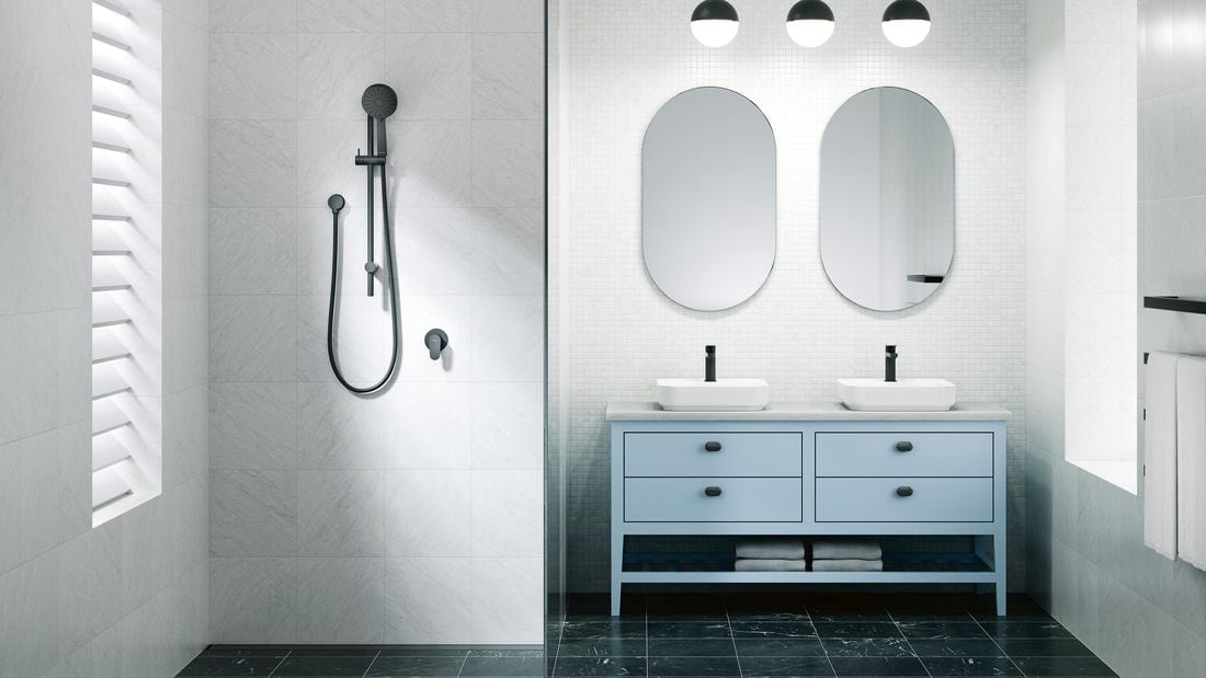 A bathroom with 2 mirrors on the wall, 2 basins on a cupboard and a shower