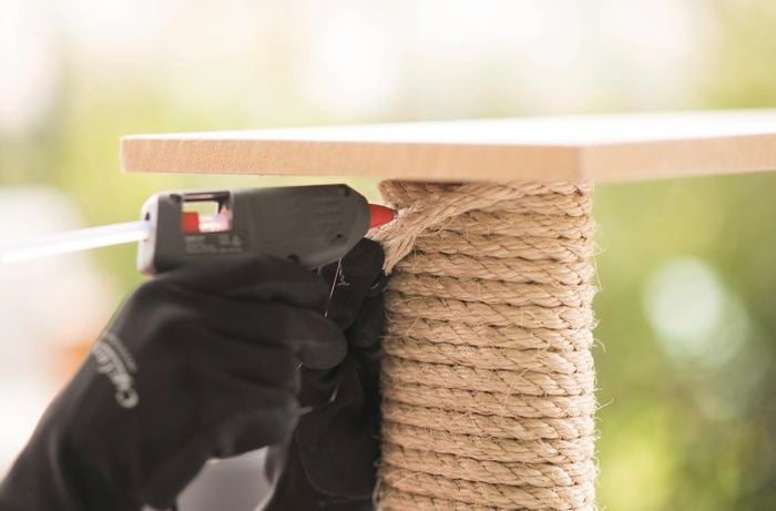 Applying glue to attach the rope to the dowel.