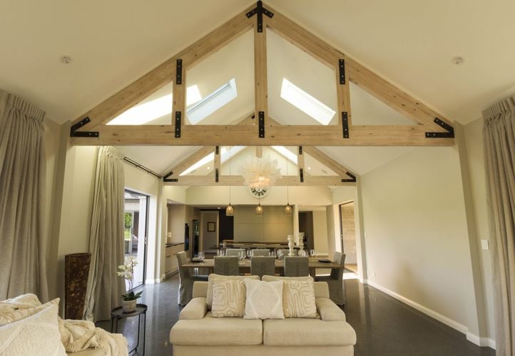 A lounge area with a high roof supported by exposed timber trusses