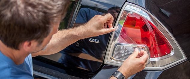Clear tape being used to repair a headlight