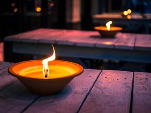 Citronella candles burning on outdoor table in the evening