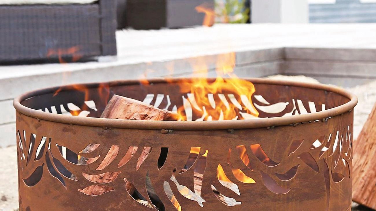 Close up shot of a metal fire pit with an open top and fire burning.