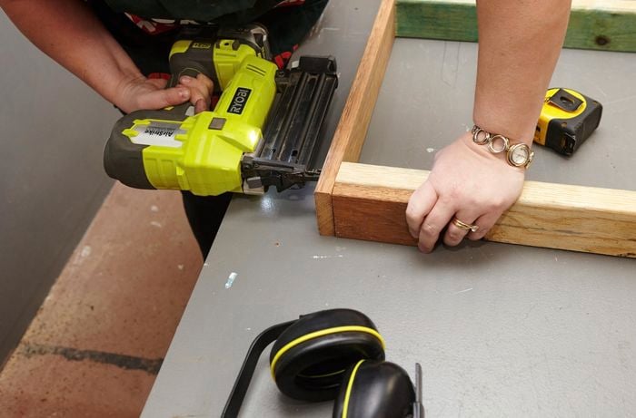 Person joining frames together with drill.