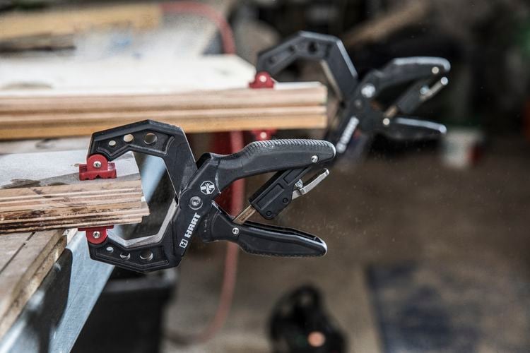 Clamps applied to a piece of particle board that was champing for a clamping