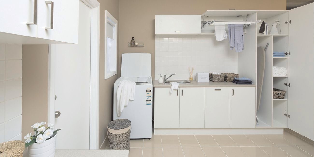 Laundry with washing machine, sink and cupboards
