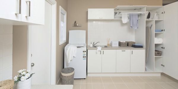Laundry with washing machine and cupboards.