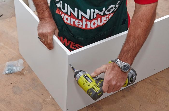 Person drilling pieces of wardrobe insert unit together.