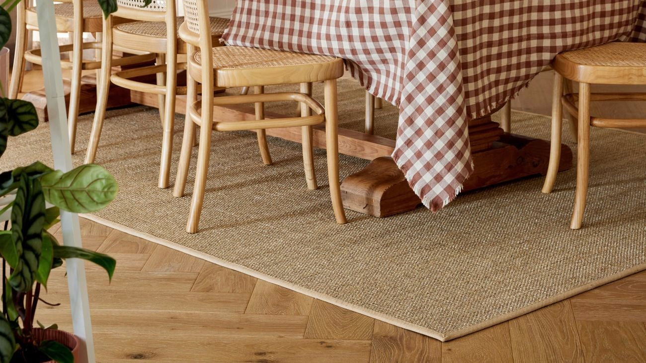 Dining room setting with dining table and chairs placed on a light brown rug.