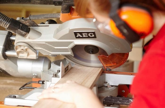 Person using circular saw to cut piece of timber to length.