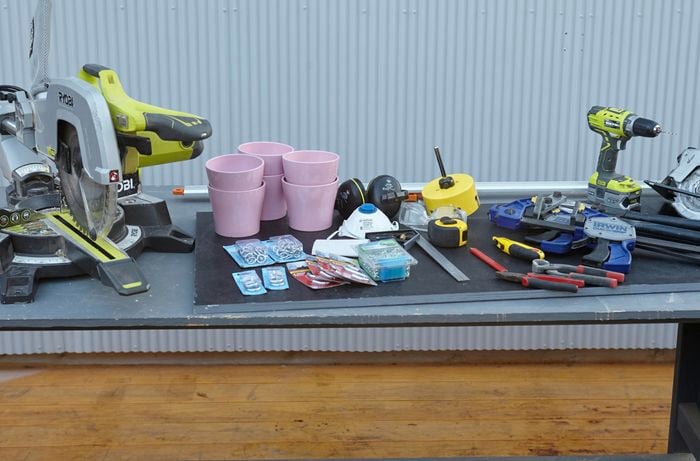 The tools and materials necessary for the job, including a mitre saw, hole saw, power drill, flowerpots, screws, chain, clamps, square rule, pliers and more
