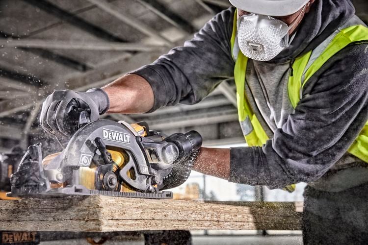 Person cutting timber with circular saw