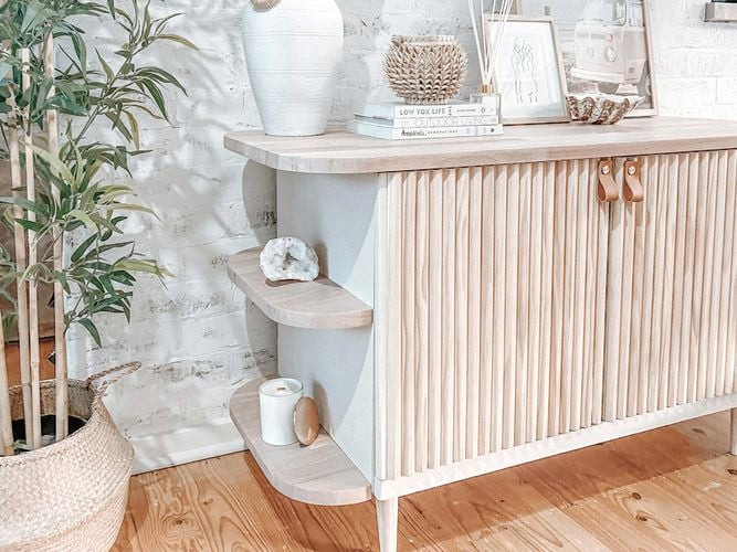 Timber side board table with  books, picture frames, sea shells
