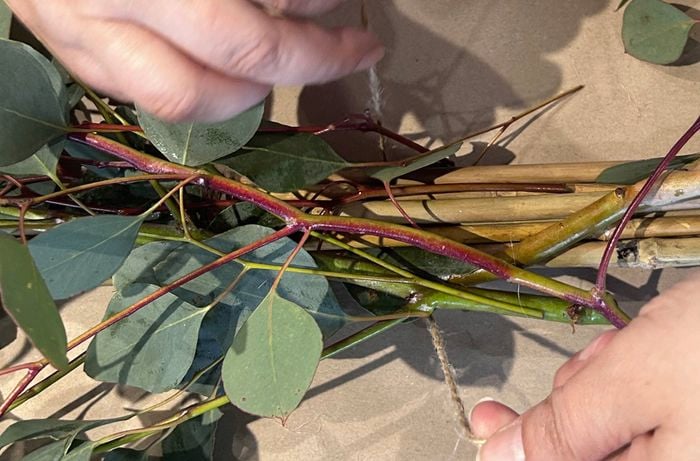 Tying foliage to a Christmas chandelier