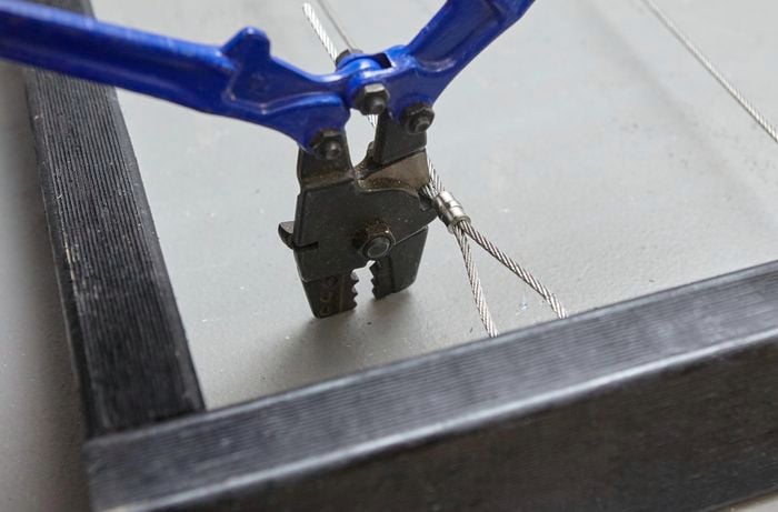 Heavy pliers being used to trim excess wire