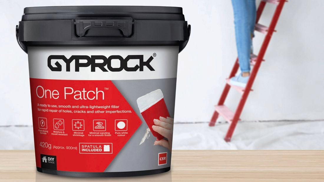 Woman on a ladder using Gyprock One Patch to repair a crack high up in a wall