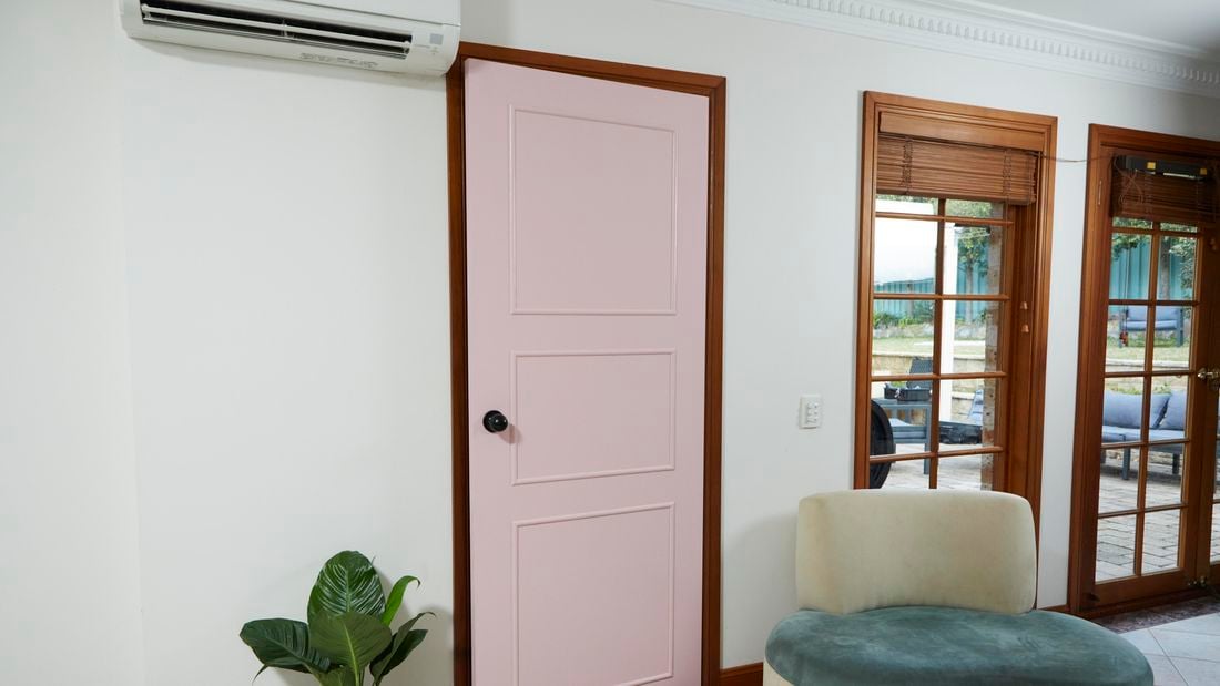 white wall with timbers windows and pink feature door