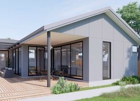 back garden with grey house and timber decking, plants and outdoor setting.