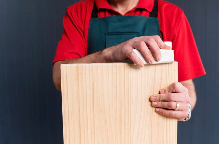 Bunnings team member sanding a piece of timber