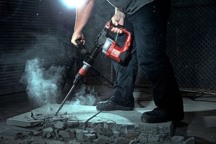 A demolition hammer breaking a sheet of concrete