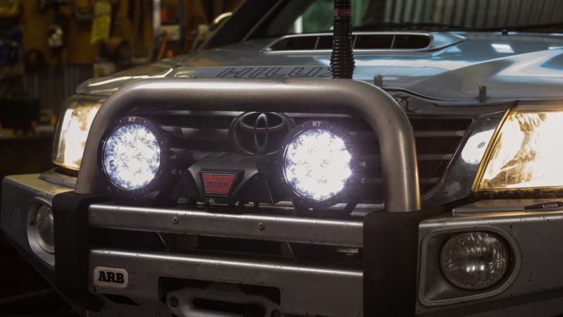 Pair of KT 7'' LED driving lights mounted to front bull bar of Toyota Hilux.