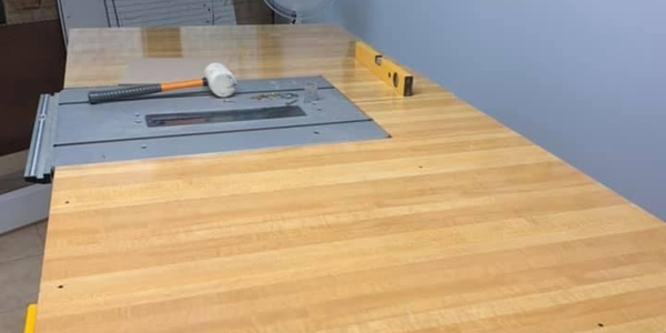 A timber workbench with built-in table saw in a workshop