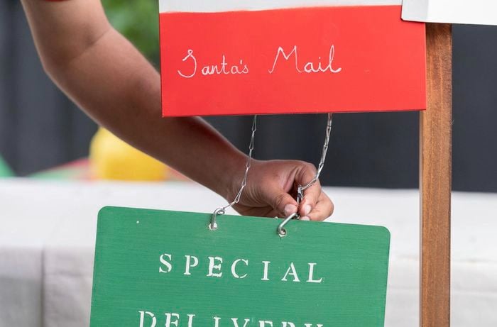 A Bunnings Team Member hanging a Special Delivery sign to a Santa's Mail sign