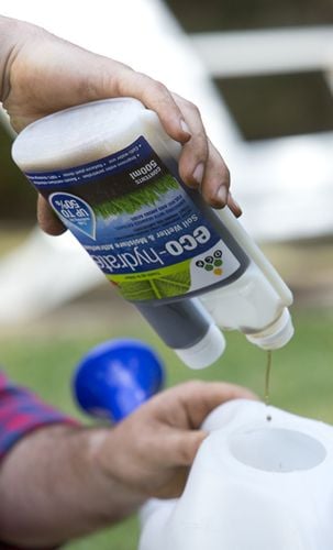 A liquid fertiliser being added to a watering can