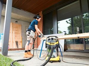 A man uses a Kärcher Wet & Dry vacuum to keep his DIY workstation free of dust