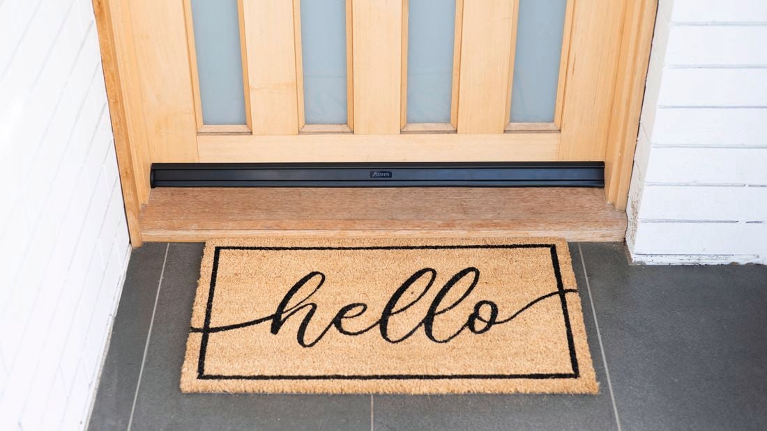 Front door with a doormat featuring the word "Hello".