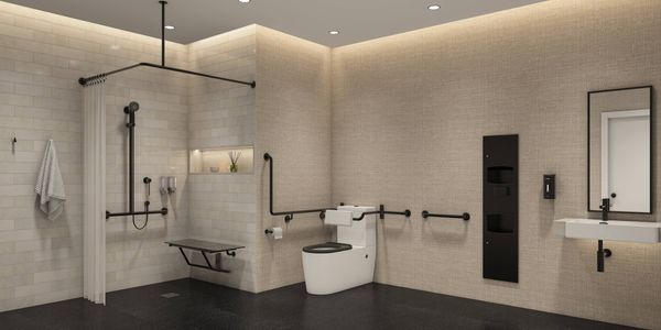 Modern accessible bathroom featuring a walk-in shower with a privacy curtain, folding shower seat, grab rails, handheld showerhead, accessible toilet, wall-mounted sink and mirror. The space uses neutral beige tones, black fixtures and open floor space to support accessibility and ease of movement.
