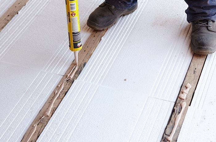 Glue being applied to a floor beam