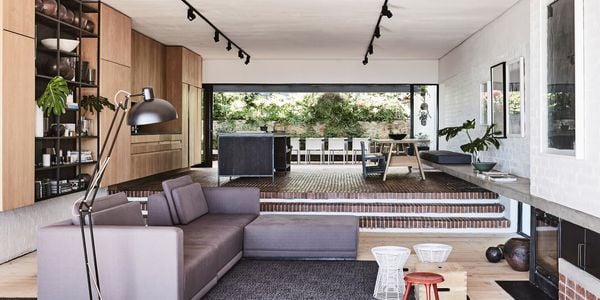 Living room with sunken lounge and long strips of pendant lighting.
