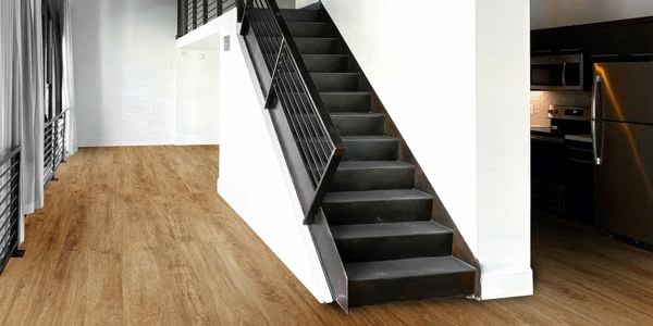 Interior of house with light HanWood flooring, dark scheme staircase and dark ceiling beams.