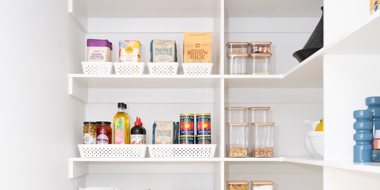 Kitchen pantry with white shelving, neatly displayed with white storage containers