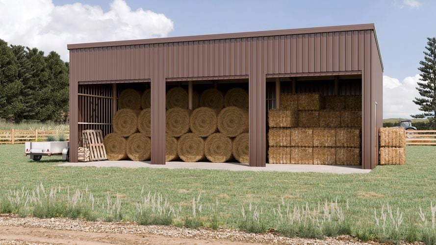 Large brown farm shed with hay bales.