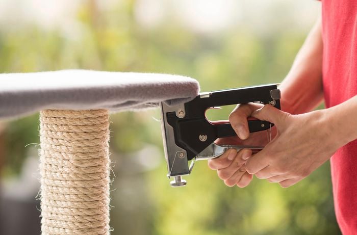 Attaching fabric to the tower using a staple gun.