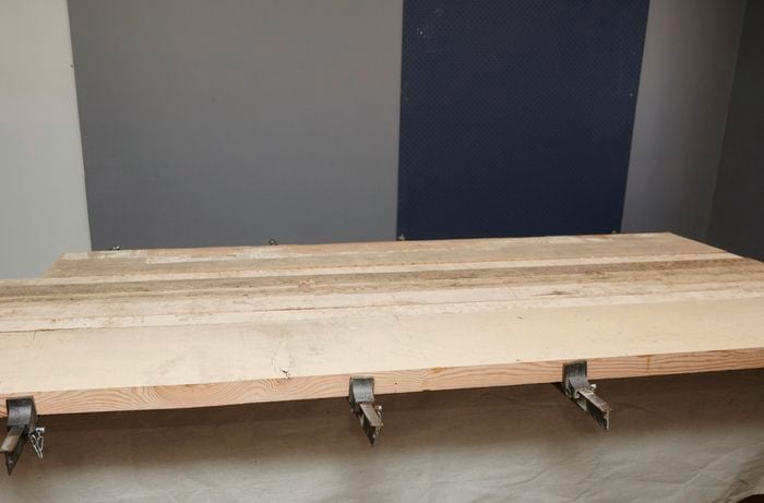 Lengths of timber for a tabletop clamped into place for gluing