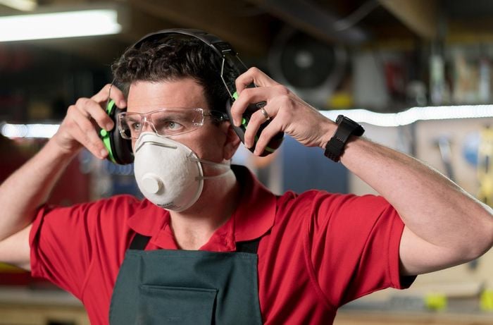 Team member wearing ear muffs and face mask