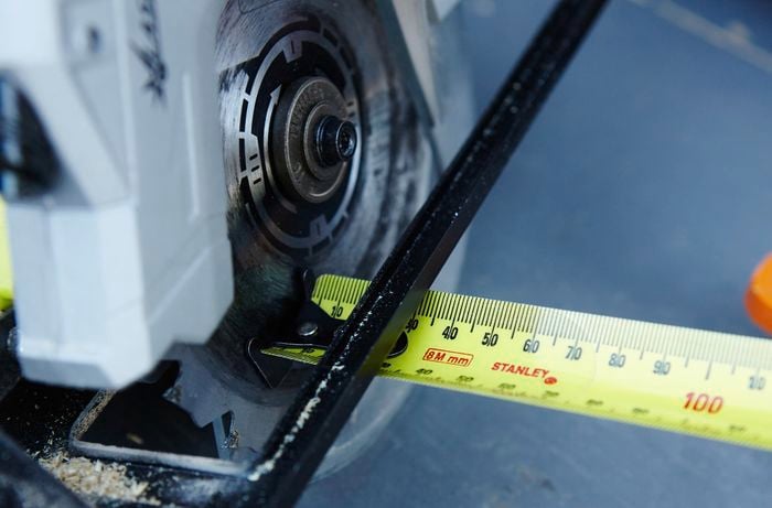 A tape measure being used to measure the length of ply to be cut