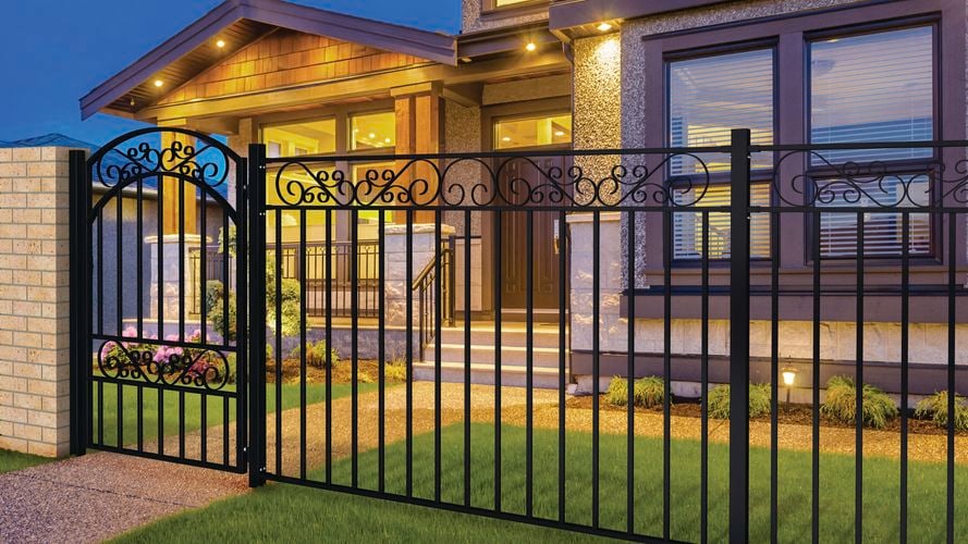 Steel gate and fence installed in front of brown two-story house